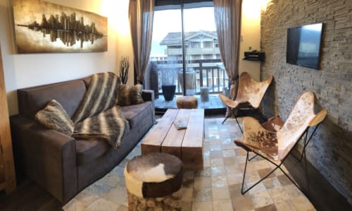 Salon luxueux de la Résidence Le Pacha à Courchevel avec balcon vue montagne, mobilier moderne et pierre