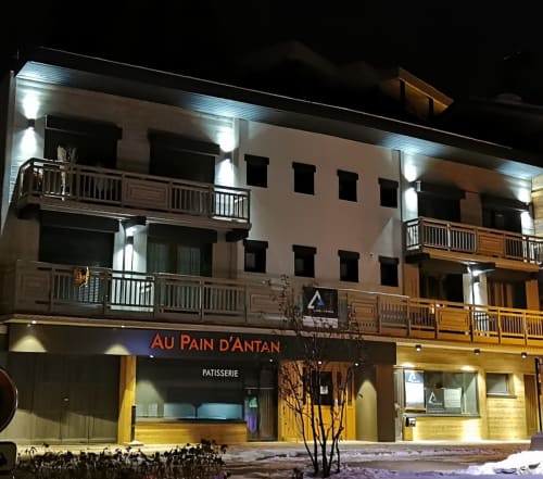 Devanture de la pâtisserie Au Pain d'Antan à Courchevel, façade alpine illuminée la nuit