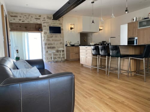 Cuisine ouverte et séjour élégants à La Ferme du Châtaignier, gîte près de Paris, avec mobilier en bois et coin bar