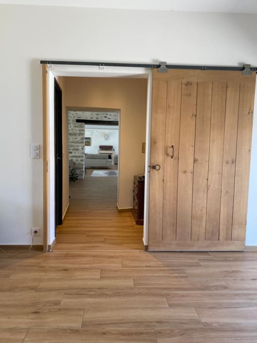 Portes de grange rustiques modernes à système coulissant ouvrant sur le couloir du gîte La Ferme du Châtaignier près de Paris