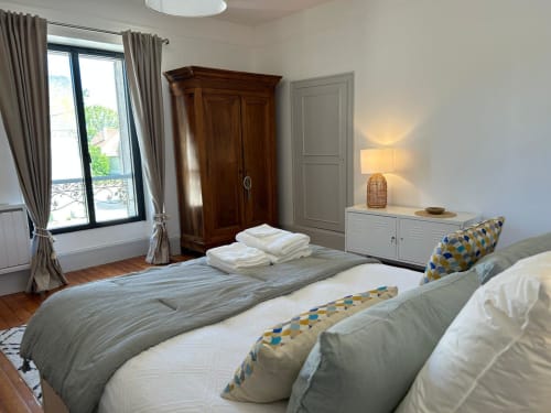 Chambre spacieuse à La Ferme du Châtaignier avec lits jumeaux, armoire en bois et vue panoramique près de Paris