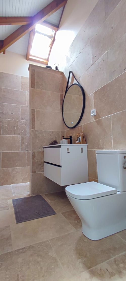Salle de bain en pierre de travertin de la chambre parentale de la villa Chacha