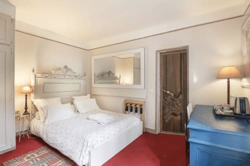 Chambre de Rita à la Maison 1850 Paris, élégante chambre avec lit blanc, tapis rouge, vue sur jardin et décor parisien classique