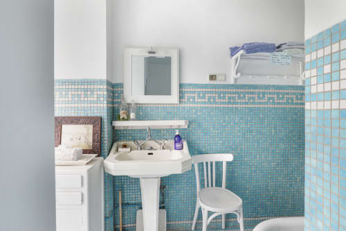 Salle de bain charmante aux carreaux turquoise dans la chambre Rita de la Maison 1850 Paris, avec lavabo sur piédestal et miroir