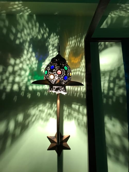 Ornamentale Zierleuchte mit farbigen Gläsern und geometrischen Mustern, die Schatten in der Suite Domaine de l'Ocrerie werfen