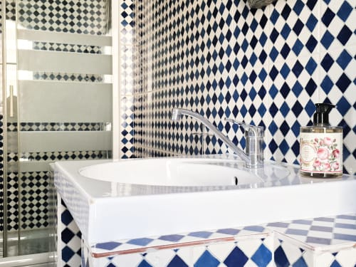 Salle de bains luxueuse à la Villa République Normandie, Caen avec carrelage losange bleu marine, lavabo blanc et équipements modernes