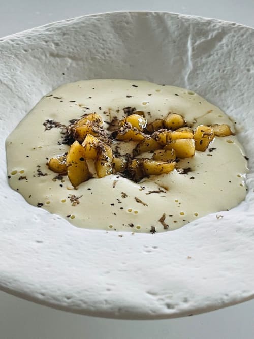 Soupe de pommes de terre crémeuse avec croûtons de patates rôties et herbes, servie au Pavillon M à Grignan