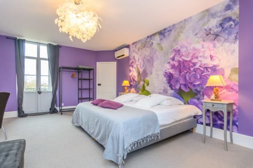 Grande chambre de couleur violette et de 30M² avec accès balcon avec grand lit de 200 X 200 et canapé.