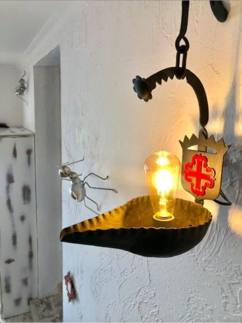 Decorative lantern with illuminated bulb and red cross shield hanging in Corral de Comedias Studio at Retiro del Teatro,