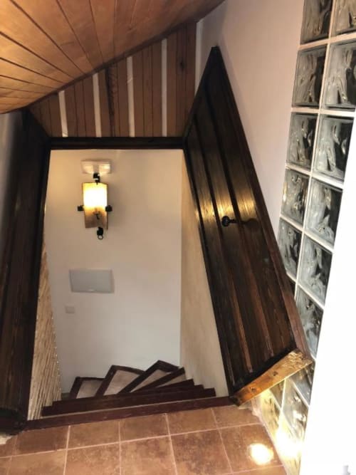 Wooden staircase in Complejo Turístico Retiro del Teatro, Almagro - elegant entrance with sconce lighting and glass block