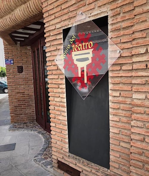 Letrero de entrada del Centro del Teatro con logo de máscara teatral roja en fachada de ladrillo en Almagro, Ciudad Real