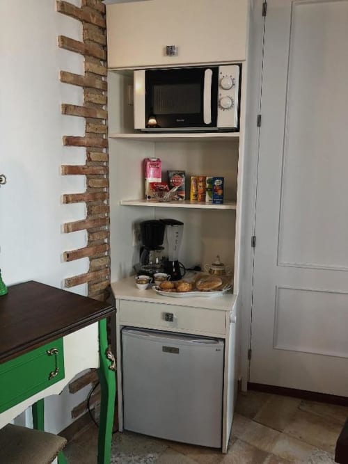 Kitchen corner in Suite B with microwave, refrigerator, coffee maker, and food items at Complejo Turístico Retiro del Teatro,