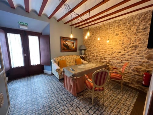 Rustic living area in Deluxe Suite at Complejo Turístico Retiro del Teatro, Almagro with stone walls, beamed ceiling, and