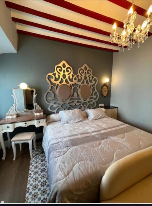 Deluxe Suite at Complejo Turístico Retiro del Teatro with queen bed, ornate headboard, red beam ceiling, and vanity desk.