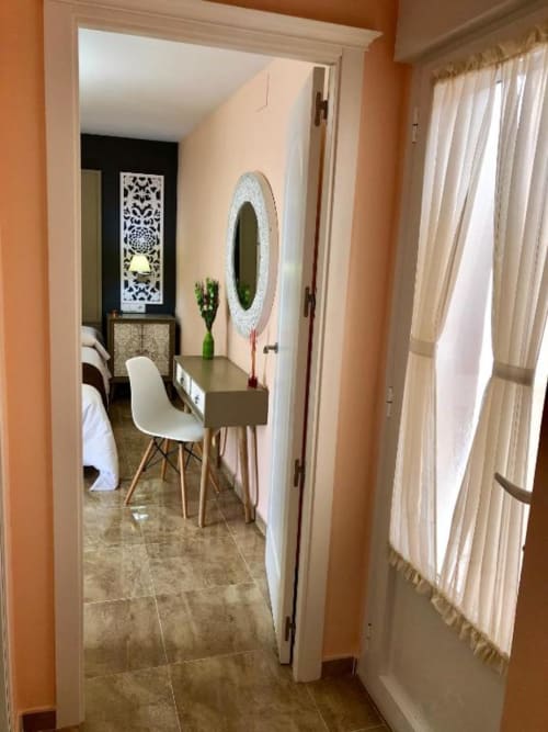 Moderno dormitorio con tocador, espejo y planta verde en Complejo Turístico Retiro del Teatro, Almagro