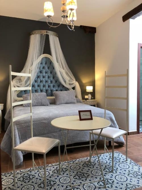 Blue Romance room with canopy bed, sheer curtains, and round table at Retiro del Teatro in Ciudad Real, Spain
