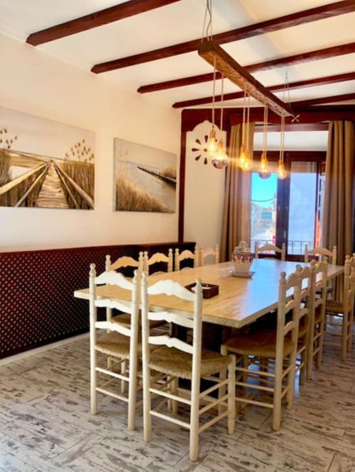 Comedor en Apartamento Corral de Comedias en Retiro del Teatro con mesa de madera, sillas blancas, vigas vistas y vistas de la ciudad