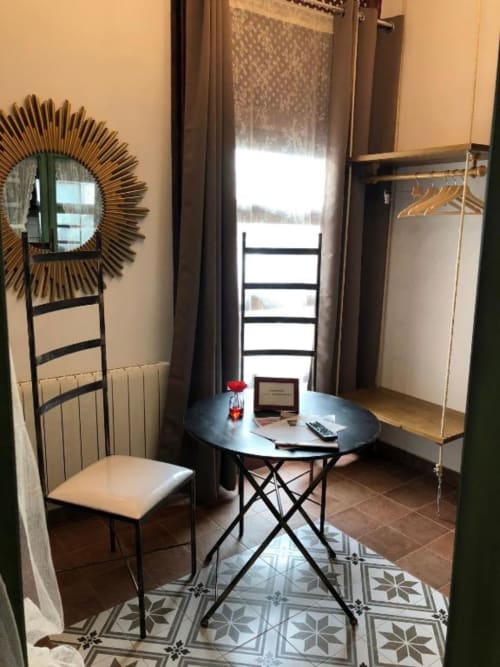 Elegant bedroom with desk, round table, and sunburst mirror at Complejo Turístico Retiro del Teatro, Almagro