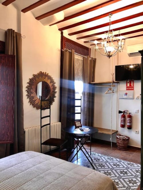 Modern bedroom at Complejo Turístico Retiro del Teatro in Ciudad Real with beamed ceiling, sunburst mirror, black round