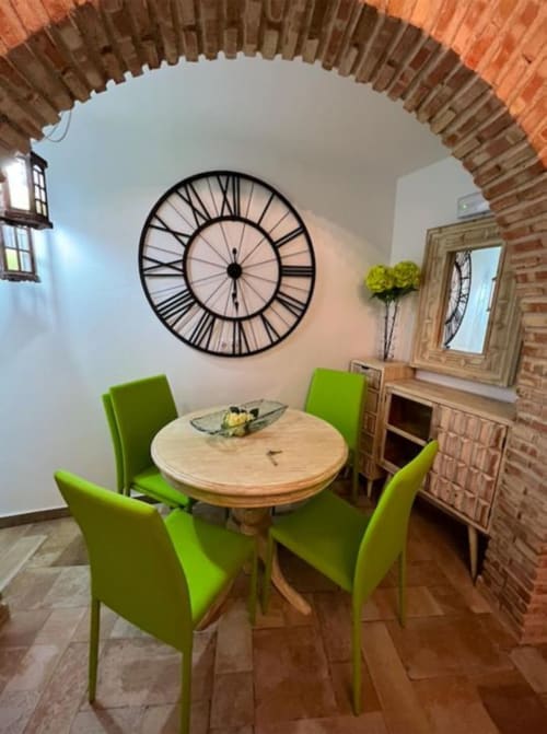 Dining area in Deluxe Apartment AB at Complejo Turístico Retiro del Teatro with round table, lime green chairs, and