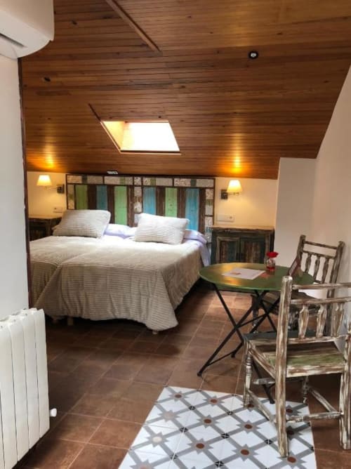 Romantic bedroom at Complejo Turístico Retiro del Teatro with wooden ceiling, queen bed, desk, and tile flooring in Almagro,