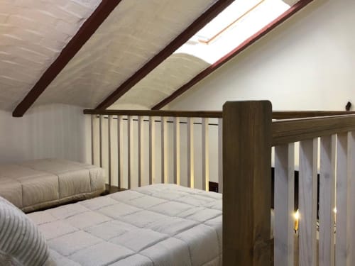 Attic bedroom with twin beds, dark wooden beams, skylight, and white vertical blinds at Complejo Turístico Retiro del Teatro,