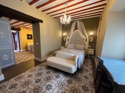 Lujosa Suite Deluxe en Complejo Turístico Retiro del Teatro con cama dosel, lámpara de araña y piso de azulejos ornamentales