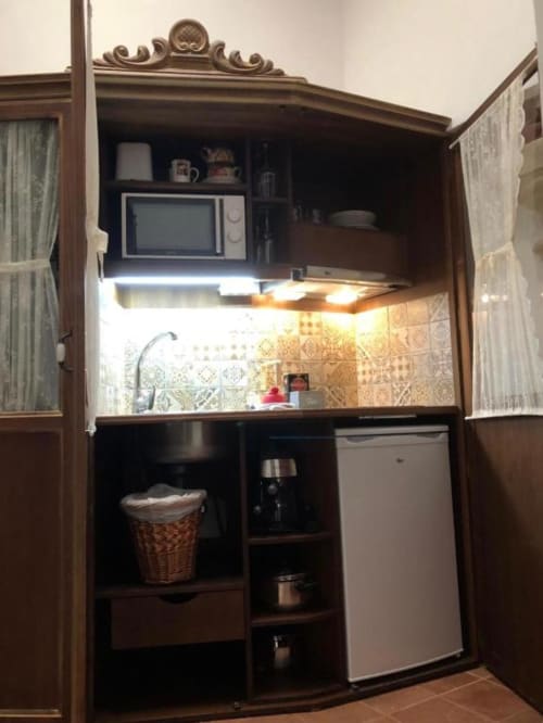Compact kitchenette in Room 5 at Complejo Turístico Retiro del Teatro with microwave, refrigerator, and stovetop