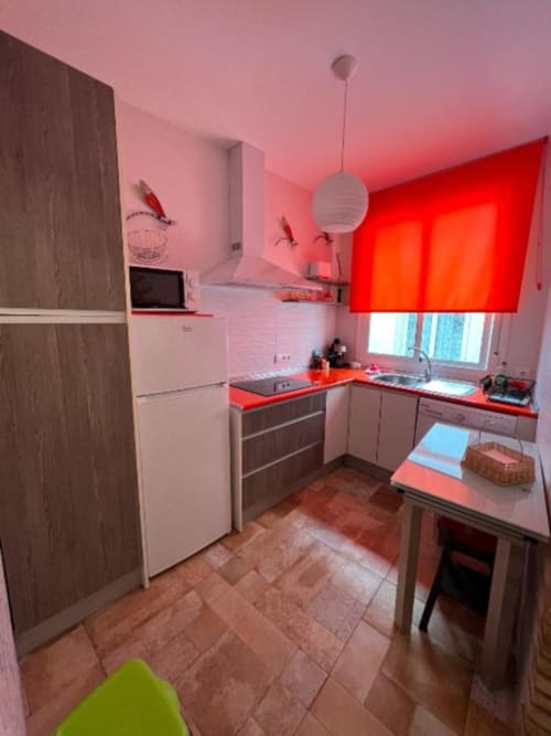 Modern kitchen in Deluxe Apartment AB at Complejo Turístico Retiro del Teatro, Almagro, with red accents and wooden cabinetry