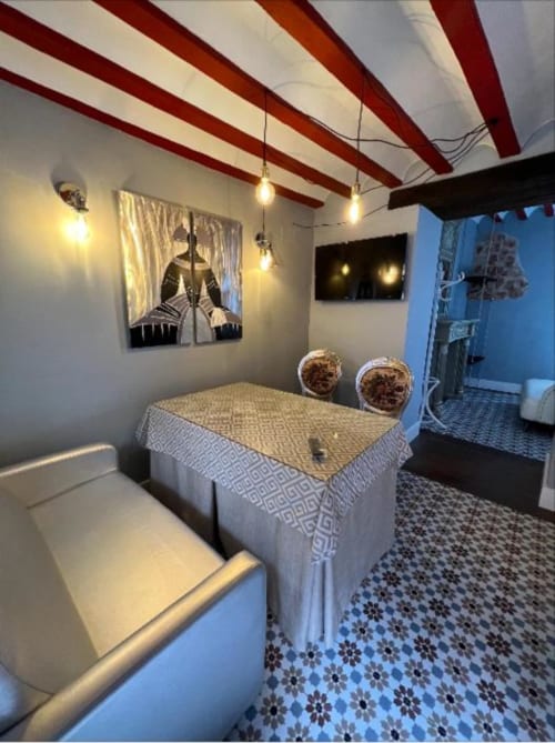 Deluxe Suite 9 at Complejo Turístico Retiro del Teatro, Almagro with modern bed, red beam ceiling, artwork, and city landmark