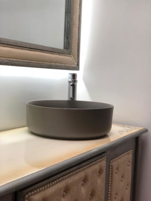 Modern gray round vessel sink with faucet on wooden vanity beneath framed mirror in Retiro del Teatro guestroom
