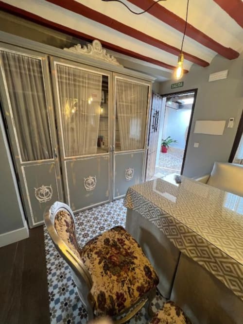 Deluxe Suite at Retiro del Teatro in Almagro with elegant furnishings, patterned chair, and courtyard views through glass