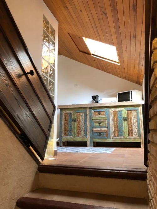 Modern rustic room entrance at Retiro del Teatro with wooden ceiling, green cabinet storage, and natural skylights in Almagro