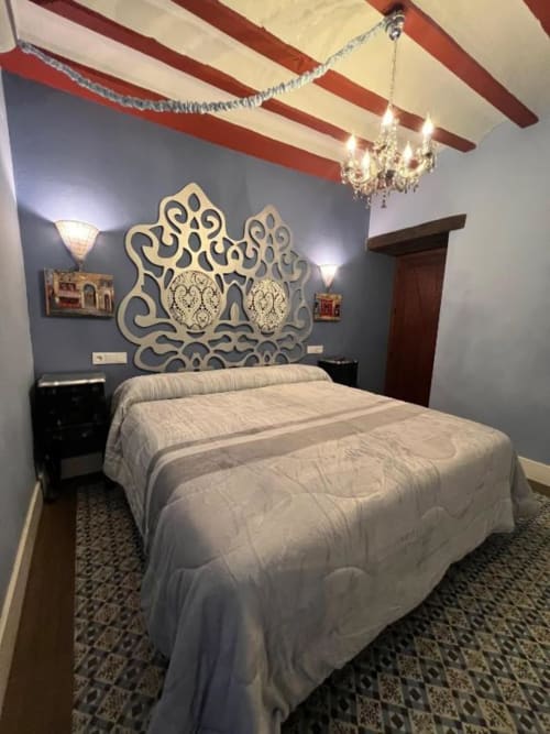 Elegant bedroom at Complejo Turístico Retiro del Teatro with ornate headboard, chandelier, and red beam ceiling