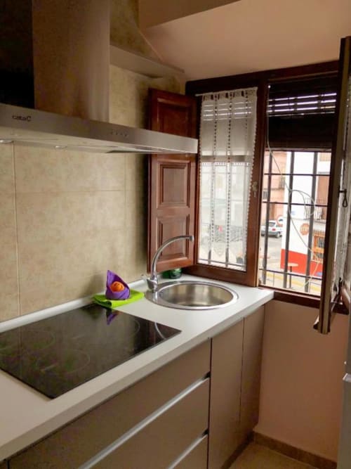 Cocina moderna en apartamento de Almagro con pileta de acero inoxidable, estufa negra y ventanas con vistas a la ciudad