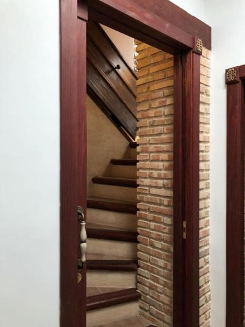 Dark wood staircase with exposed brick wall in Retiro del Teatro room, Almagro