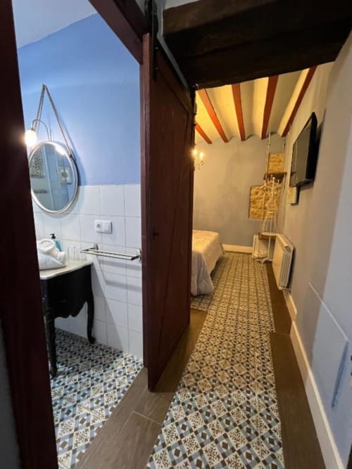 Bright hallway with patterned tile flooring at Complejo Turístico Retiro del Teatro, leading to bedroom with bathroom entry