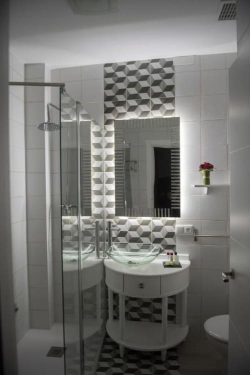 Baño moderno en Apartamento Deluxe del Complejo Turístico Retiro del Teatro con diseño geométrico de azulejos, lavamanos redondo, ducha,