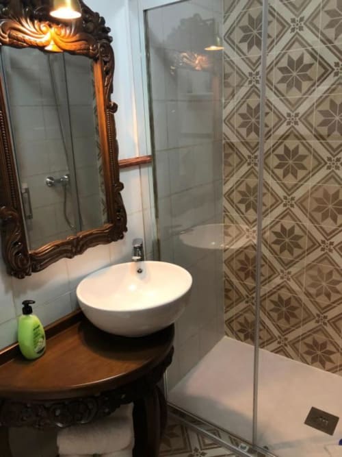 Elegant bathroom in Room 5 at Retiro del Teatro with round vessel sink, ornate mirror, patterned shower enclosure, wood