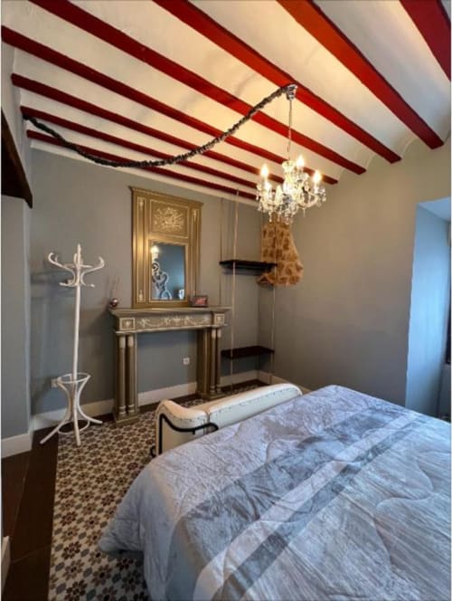 Deluxe Suite 9 at Retiro del Teatro with striped red ceiling, crystal chandelier, ornate vanity, and bed with landmark views,