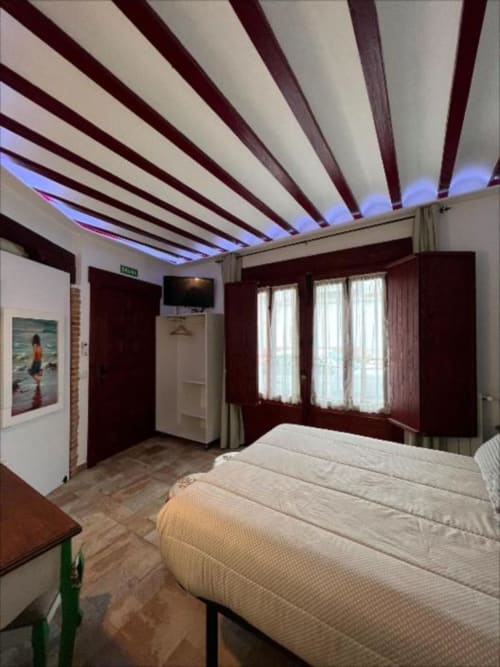 Modern Suite B at Complejo Turístico Retiro del Teatro with striped ceiling, bed, and landmark views in Almagro