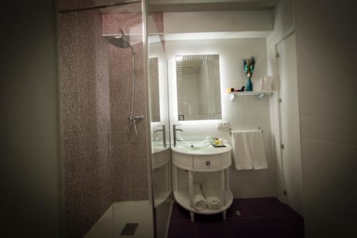 Moderno baño en Apartamento Deluxe del Complejo Turístico Retiro del Teatro, Almagro con ducha de cristal, lavabo, espejo y