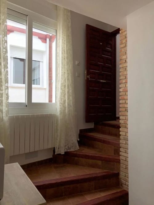 Modern staircase with dark wood steps, white walls, and a brick accent wall in Room 3 at Complejo Turístico Retiro del