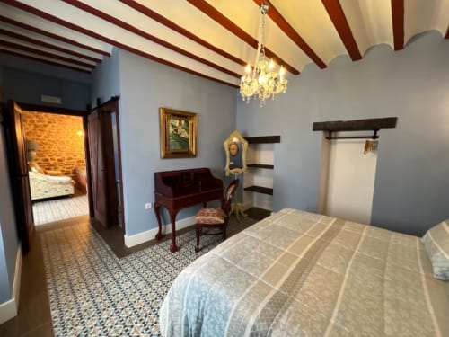Deluxe Suite 12 at Complejo Turístico Retiro del Teatro with bed, sofa, exposed beams, chandelier and city views in Almagro,