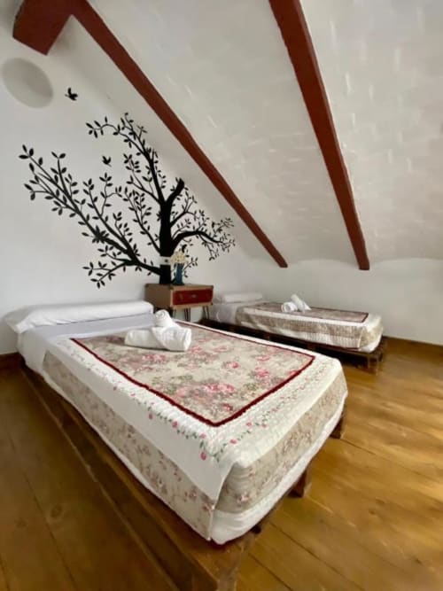 Spa-style massage bed with floral bedding in treehouse-themed room at Retiro del Teatro, Almagro hotel
