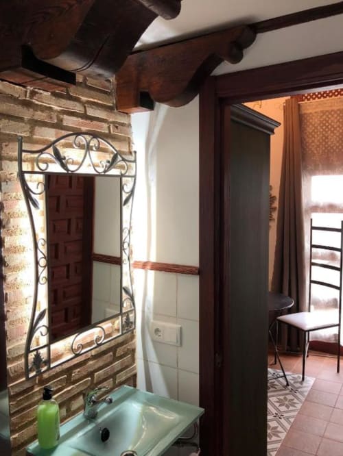 Bathroom with ornate mirror and brick walls in Almagro room at Complejo Turístico Retiro del Teatro, Spain
