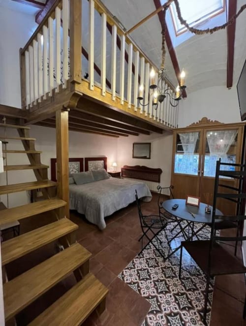 Loft bedroom with mezzanine at Complejo Turístico Retiro del Teatro, Almagro featuring wooden stairs, bed, and modern