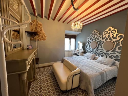 Elegant bedroom in Almagro with striped ceiling, decorative headboard, beige furnishings, and city views at Complejo