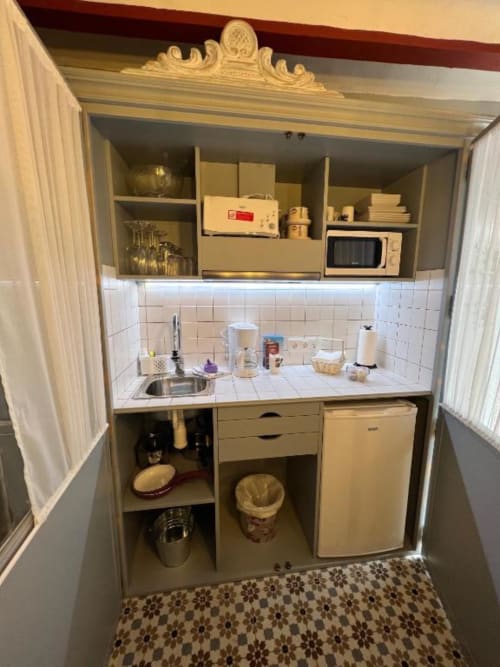 Compact kitchenette in Deluxe Suite at Complejo Turístico Retiro del Teatro with sink, microwave, refrigerator and white tile