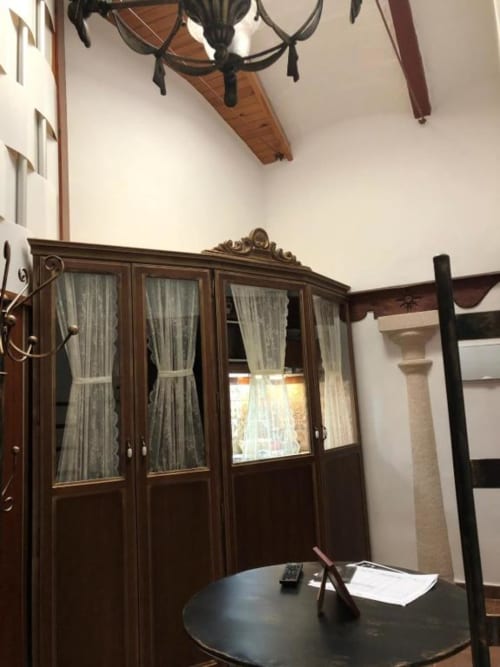Classic elegantly furnished room with dark wooden wardrobe, round desk, and period chandelier at Complejo Turístico Retiro